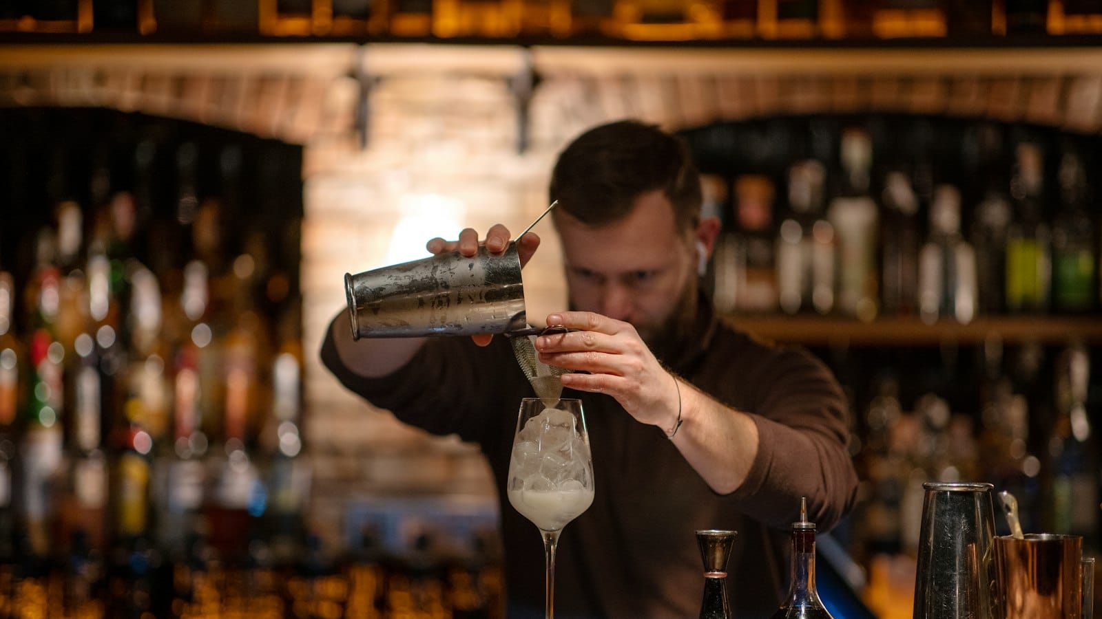 A bartender making a drink behind a bar