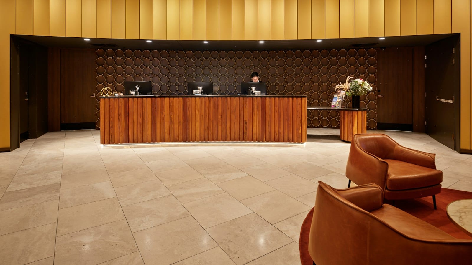 A hotel reception desk with seating in the lobby