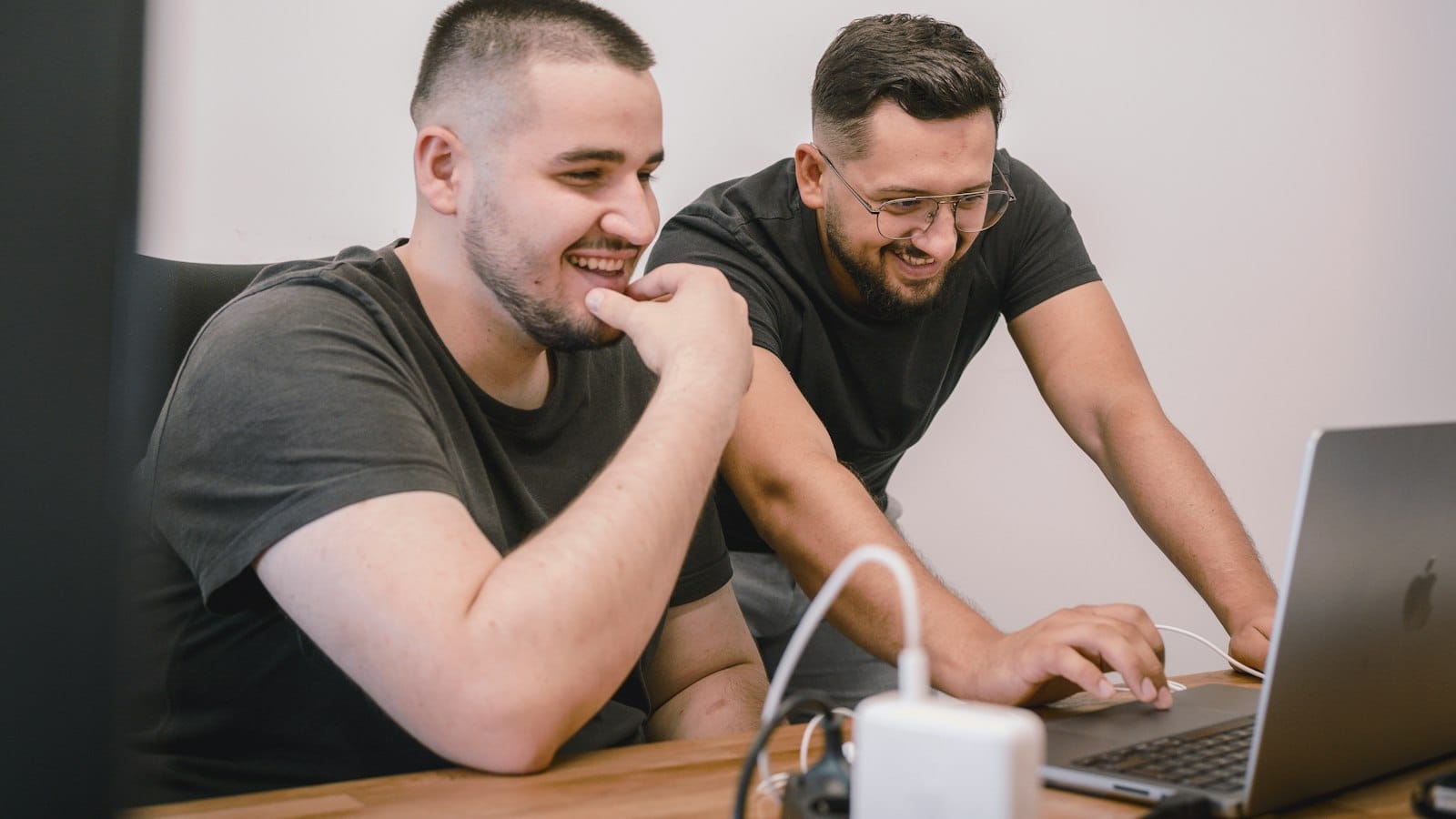 Colleagues talking at a desk in a small office