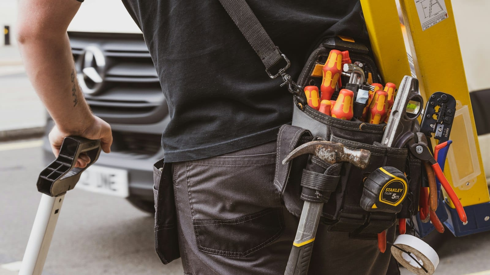 A tradesperson holding a power tool