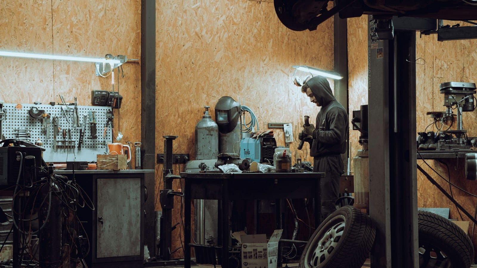 A mechanic working on a machine in a garage workshop